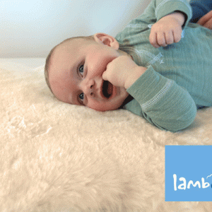 Smiling baby lying on lambskin rug