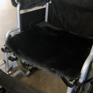 Dark grey sheepskin seat cover on wheelchair