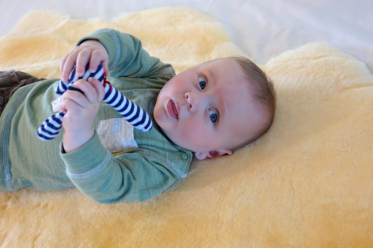 Baby on pale gold lambskin rug