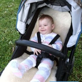 Smiling baby on ivory stroller liner